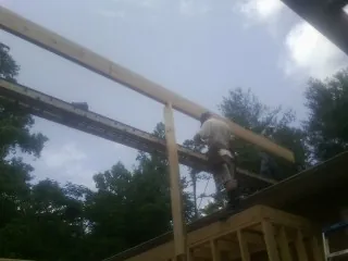Carpenter setting a ridge beam over a new addition frame — Ice Dam Removal by Roofing Brothers in Glenside