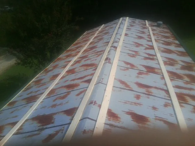 Rusted metal roof panels with new wood purlins before replacement — Storm Damage Roof Repair in Glenside by Roofing Brothers