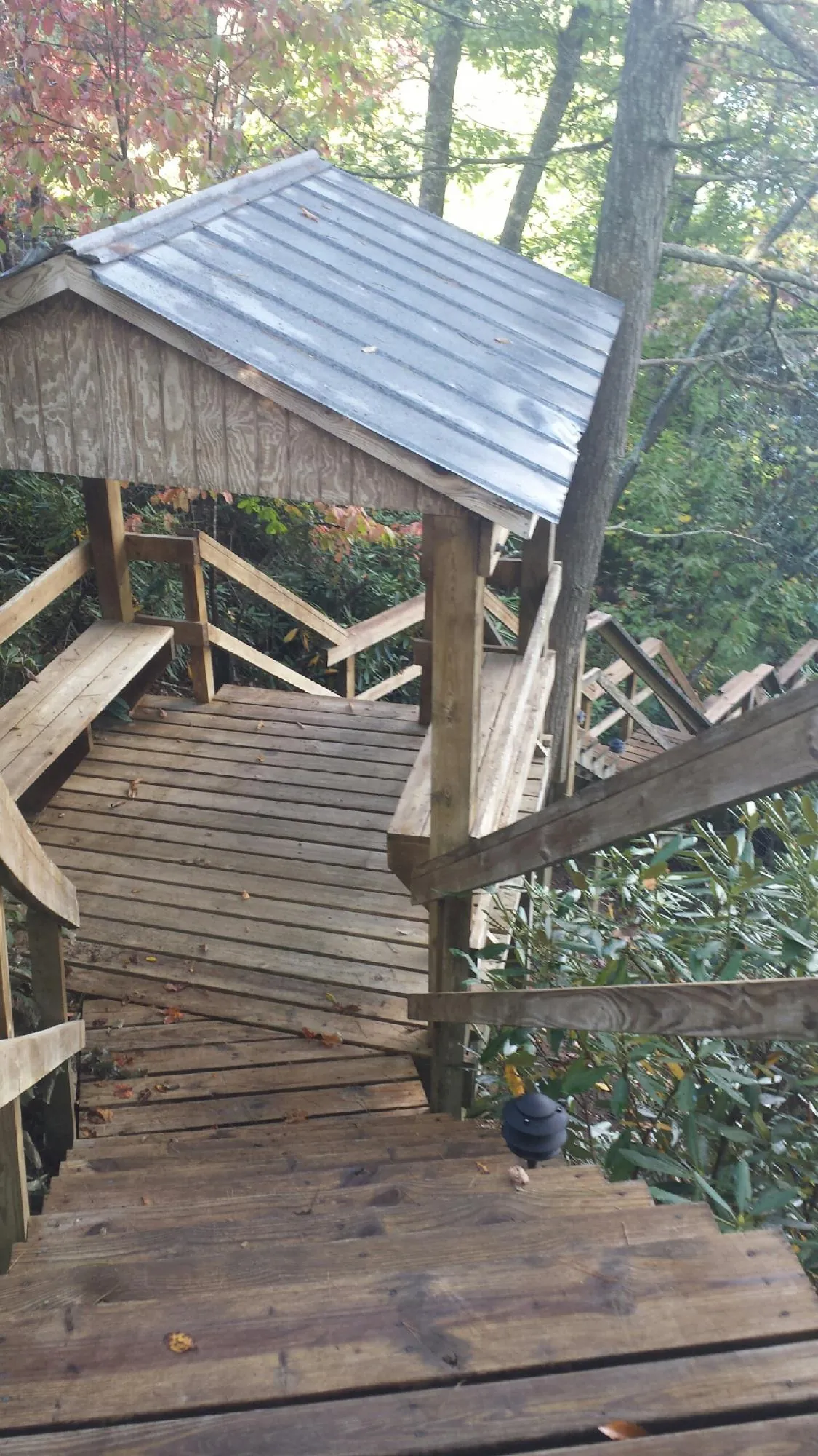 Metal roofed shelter over wooden steps on a wooded walkway — Skylight Repair & Installation work by our crew in Glenside
